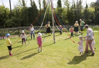 Children dance around a maypole at an English country festival, Shottisham, Suffolk, England,