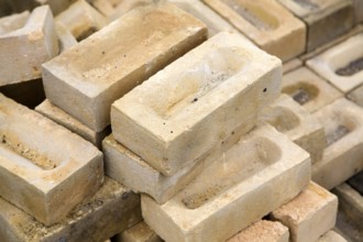 Clay bricks piled up in builder's yard, UK