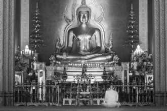 Monk meditating, Golden Buddha statue, Bhumispara-mudra, Buddha Gautama at the moment of