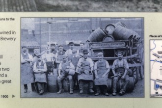 Old information notice with historic photo of male men brewery workers, Halesworth, Suffolk,