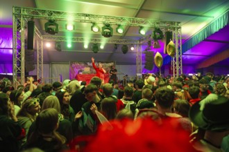 Schlagerkönig Tobee A party with a lively atmosphere on a stage under green lighting, carnival,