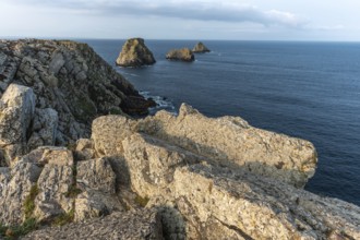 The tip of Pen Hir and its peach stacks. The rocks are jagged and rough, while the water is calm.