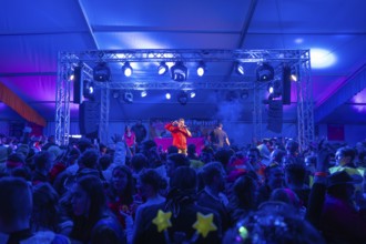 Schlagerkönig Tobee, A stage with blue lighting in a party tent full of celebrating people,