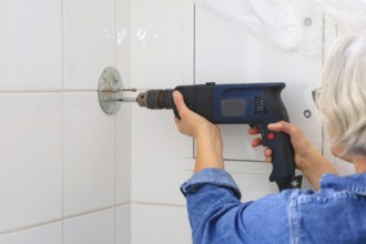 Renovating the bathroom, do-it-yourselfer with drill, Germany, Europe