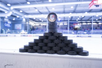 Stacked ice hockey pucks in an ice rink on the sidelines, Heilbronner Falken Vs Bietigheimer