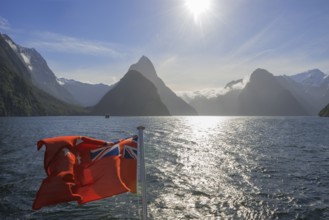 New Zealand flag waving, Milford Sound, South Island, Southland, New Zealand, Australasia, Oceania