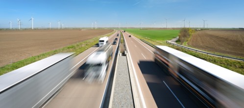 Motorway A38 near Querfurt, trucks and cars in motion blur, wind turbines on the horizon,