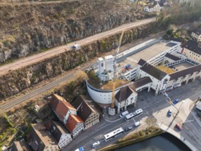 Crane and building in an urban environment, surrounded by roads, railway and landscape, extension