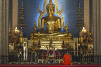 Monk meditating, Golden Buddha statue, Bhumispara-mudra, Buddha Gautama at the moment of