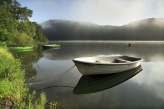 Morning atmosphere with fog over the lake, rowing boats, fishing boats lying on the shore, Edersee,