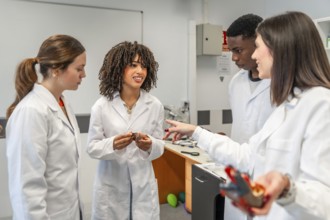 Diverse group of university students learning anatomy in laboratory with teacher guiding them