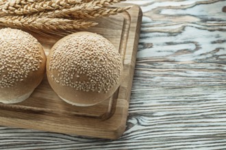 Chopping board bread rye ears on wooden surface