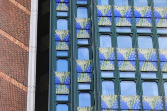 Modern building façade in blue-green with geometric patterns in an urban context, Vienna, Austria,