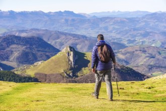 Male hiker enjoying the view of the mountains and valleys of the basque country while trekking