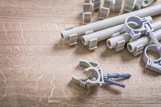 Aerial View Big Composition Polypropylene Fixators And Pipe With Clips On Wooden Board