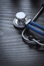 Close up of medical stethoscope on wooden board medicine concept