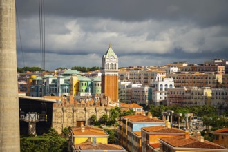 Cityscape featuring colorful buildings and historical architecture under a cloudy sky, cable car,