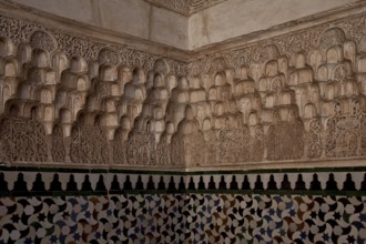 Nasrid palace, stucco wall decoration over tiled plinth in a corner of the room