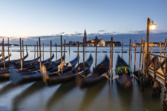 Morning atmosphere in front of sunrise, gondolas, San Giorgio Maggiore church in the background,