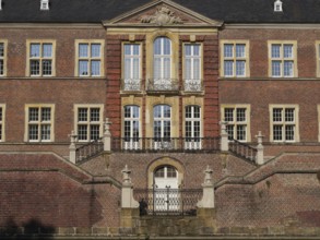 Magnificent red brick castle façade with ornate windows and symmetrical staircase, ahaus,