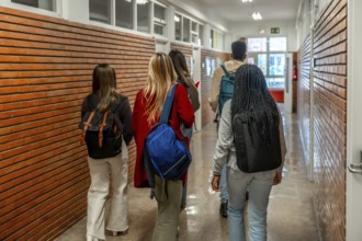 Group of diverse high school or university students walking down school hallway between classes