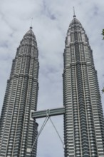 Two iconic twin towers under a cloudy sky, imposing modern design, kuala lumpur, malaysia