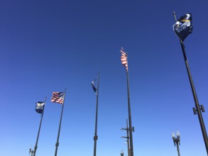 Various flags hoisted high in the clear blue sky flutter in the wind, chicago, illinois, usa