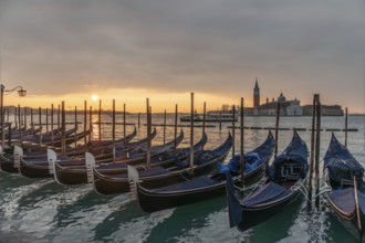 Cloudy atmosphere at sunrise, gondolas, San Giorgio Maggiore church in the background, Venice,