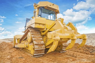 Bulldozer yellow coloured standing on sand rear view