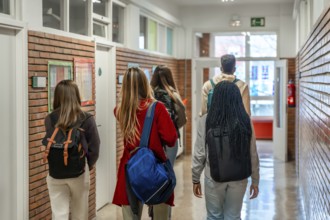 Diverse group of high school students walking together down a bustling school hallway, carrying