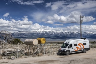 Motorhome parked in front of truck stop with oil barrels and a fence of deer antlers, Highway 50,