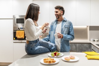 Happy couple sharing a moment together, drinking coffee and enjoying a selection of pastries in