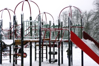 Snowstorm covering playground in park, London, UK United Kingdom England