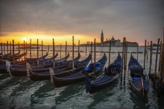 Cloudy atmosphere at sunrise, gondolas, San Giorgio Maggiore church in the background, Venice,