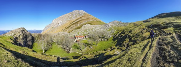 Majestic view of hiker exploring the picturesque txindoki mountain range in the basque country,