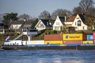 Container cargo ship on the Rhine near Düsseldorf-Bockum, villas on the banks of the Rhine, the