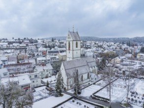 Historic church in the centre of a snow-covered town, photographed from the air, Aidlingen,