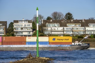 Container cargo ship on the Rhine near Düsseldorf-Bockum, villas on the banks of the Rhine, the