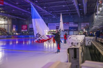 Large flags are waved on an illuminated ice rink during an event, Heilbronner Falken Vs