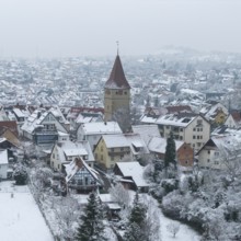 Traditional village with church in wintry silence and snow-covered roofs, Korb-Steinreinach,