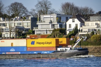 Container cargo ship on the Rhine near Düsseldorf-Bockum, villas on the banks of the Rhine, the