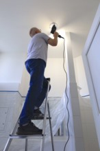 Fitting a ceiling light in the bathroom, Germany, Europe