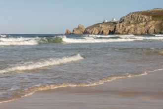 The sea is calm and the beach is sandy. The waves are small and the water is a light blue colour.