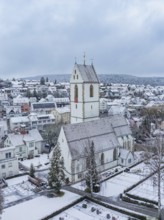 Snow-covered church tower and surrounding municipal buildings in a wintry landscape, Aidlingen,