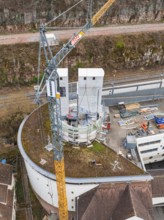 Construction project on a round building with crane and materials in an urban environment,