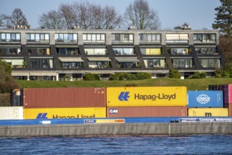 Container cargo ship on the Rhine near Düsseldorf-Bockum, villas on the banks of the Rhine, the