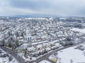 Large snowy cityscape with open fields behind, under a cloudy sky, Aidlingen, Böblingen district,