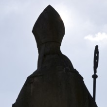 Statue of Bishop Boniface with mitre and crozier against the light, Freckenhorst, Münsterland,