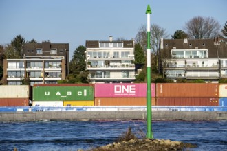 Container cargo ship on the Rhine near Düsseldorf-Bockum, villas on the banks of the Rhine, the