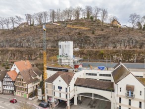 Cityscape with construction site, concrete tower, crane and surrounding historical architecture,